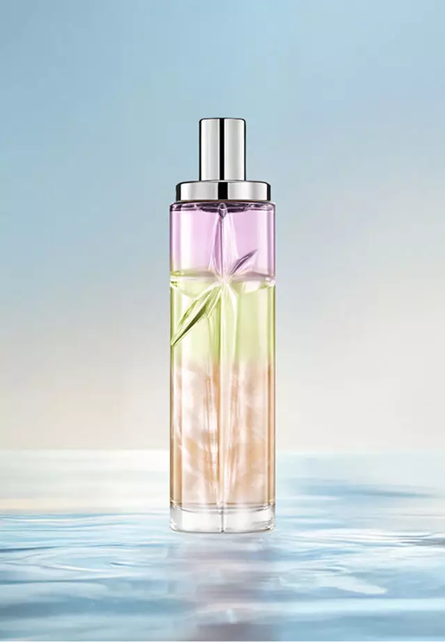 Yummy Swirl Starlicious layering recipe: tall bottle with purple, green and orange gradient on water against a soft blue background. Creamy, tropical, subtly nutty scent with a hint of berry; 2 sprays Pineapple Musk, 1 Pistachio Praline, 1 Berry Licorice.